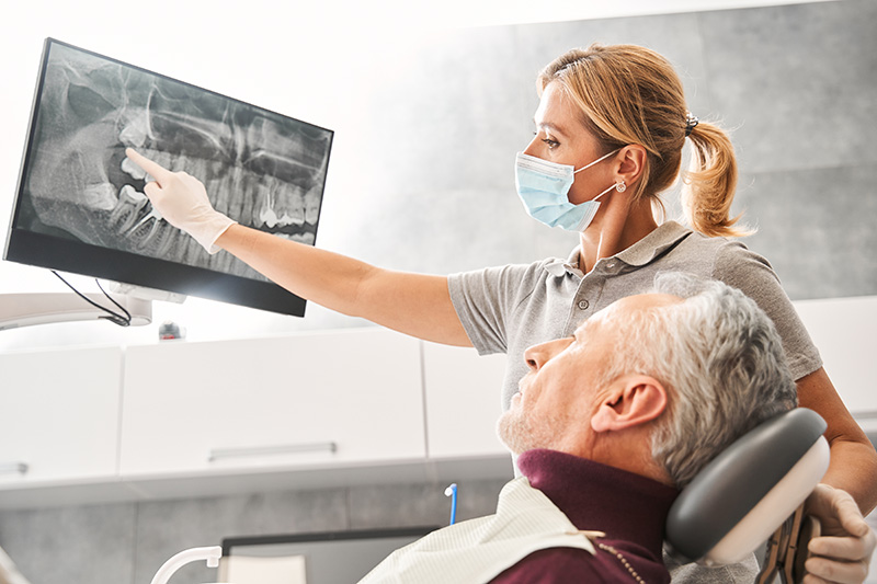 Dentist showing at the x ray and explaining