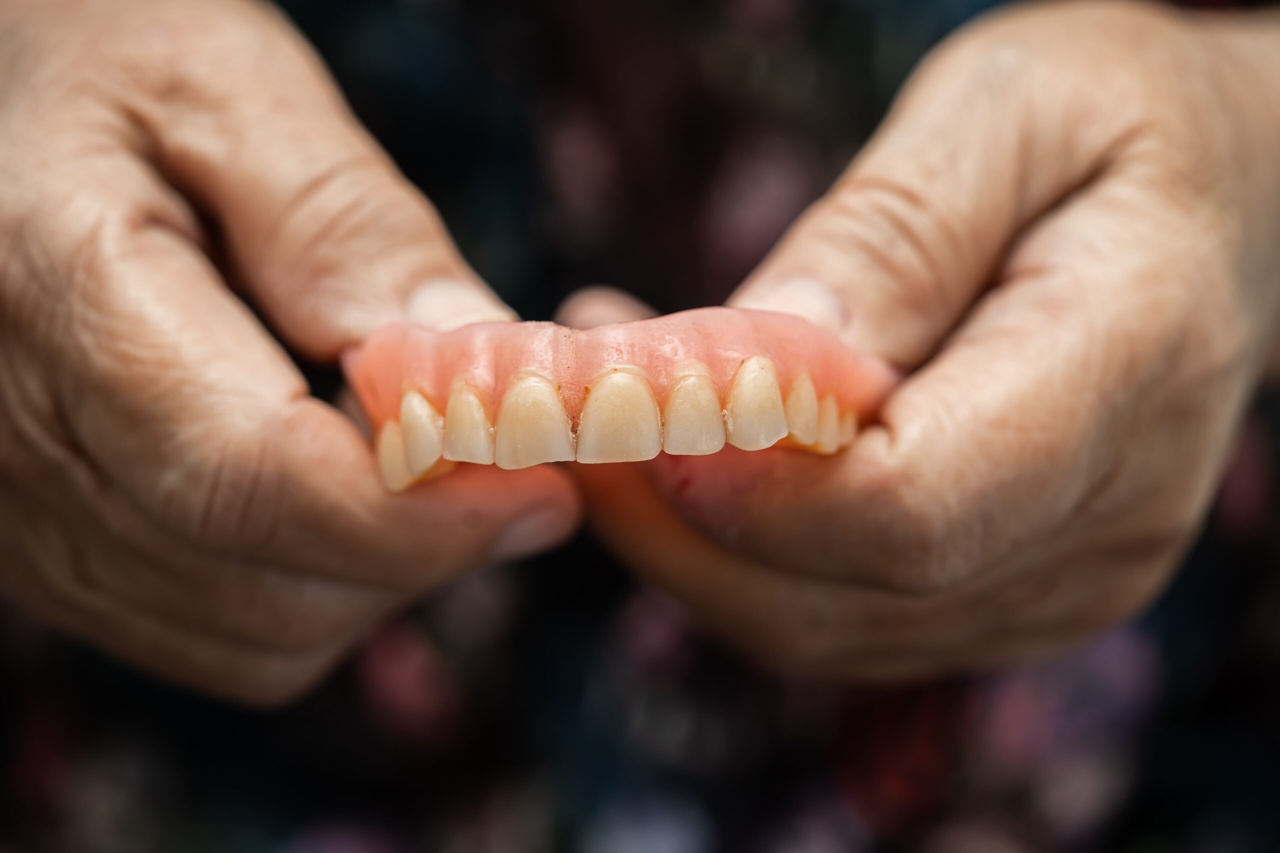 Asian senior or elderly old woman patient holding to use denture